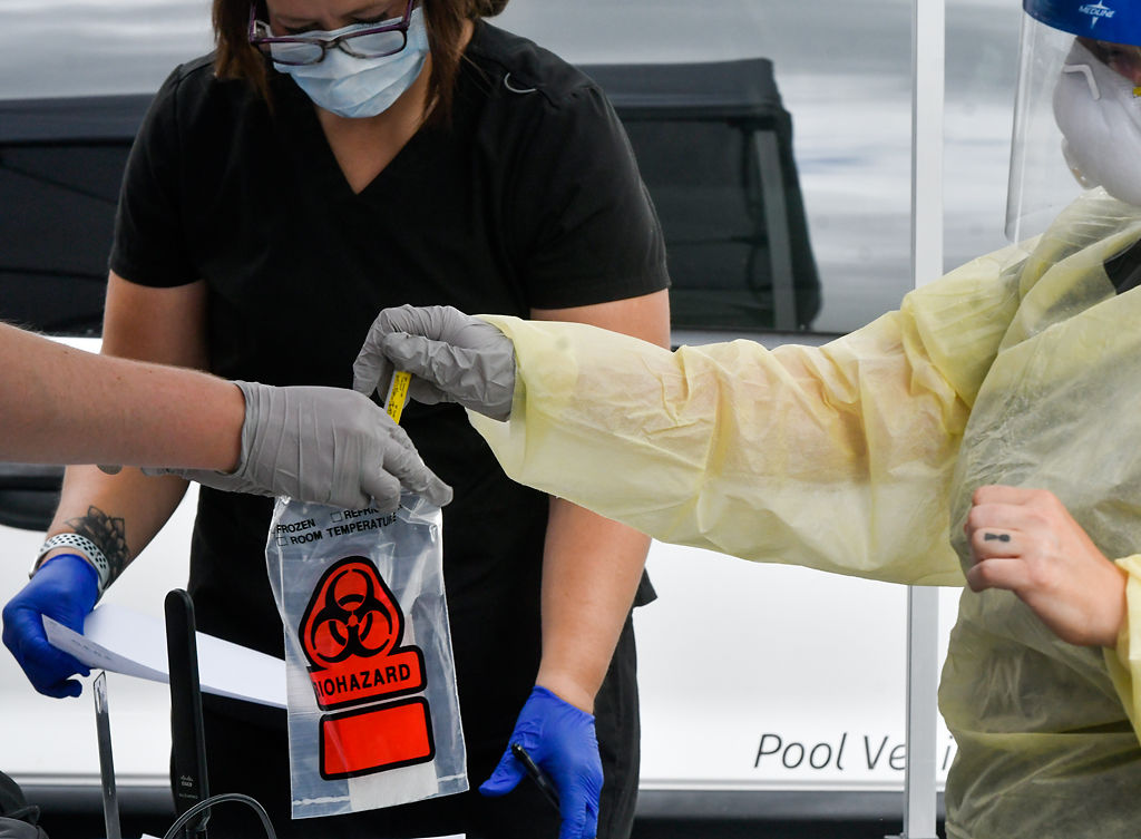 Crystal Smith puts a labeled test tube into a medical bag